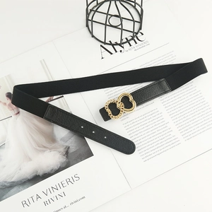 Women's black elastic waist belt featuring an interlocking gold double heart buckle