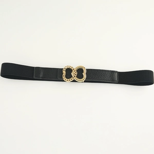 Detail of black elastic belt with golden intertwined heart buckle and faux leather texture
