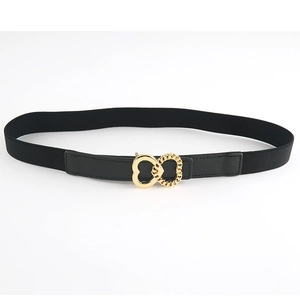 Detail of interlocking gold double heart buckle on black elastic waist belt for dresses