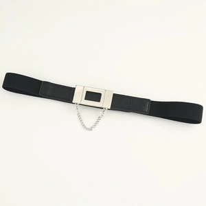 Detail of black elastic belt with silver square buckle and dangling metal decorative chain