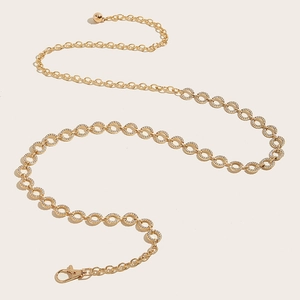Macro shot of gold circular rhinestone waist chain with adjustable lobster clasp and metal ball