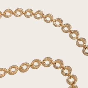 Detailed close-up of golden metal chain belt featuring rhinestones for dresses