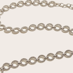Detailed close-up of sparkling rhinestone pavé silver metal ring chain belt for dresses