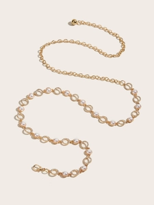 Detail of gold metal waist chain with rhinestone circles and elegant white pearls