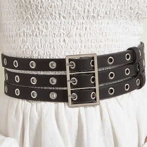 Détail d'une ceinture punk noire à trois couches avec œillets argentés et boucle en métal