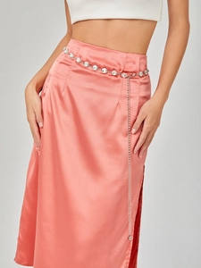 Elegant rhinestone waist chain belt accessory on pink satin skirt with side slit detail