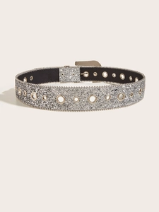 Détail d'une ceinture à paillettes argentées avec œillets métalliques et boucle brillante