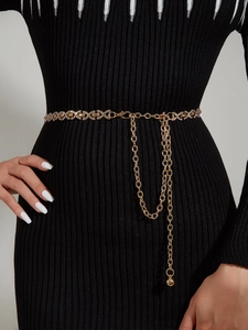 Détail de la chaîne de taille dorée en strass avec maillons en X et doubles pendentifs