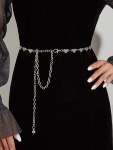 Detail of silver heart rhinestone waist chain belt on black dress with tassel fringe
