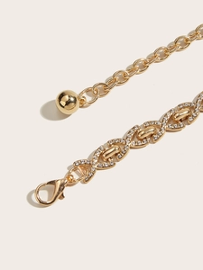 Détail macro d'une chaîne de taille dorée avec strass et fermoir mousqueton