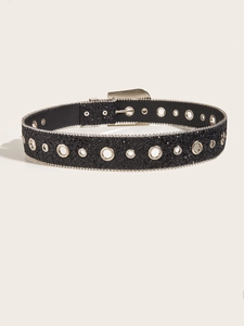 Détail d'une ceinture noire à paillettes avec œillets argentés et bordure cloutée punk