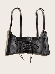 Detail of black faux leather lace-up corset belt with silver metal eyelets and buckles