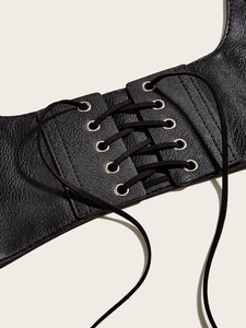 Close-up of black punk style lace-up waist corset with silver metal eyelets and litchi texture