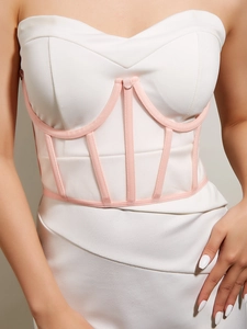 Détail d'une robe bustier blanche avec structure à baleines roses et corset