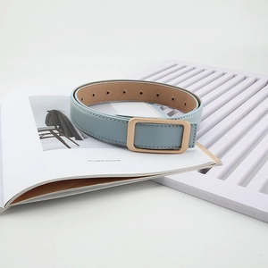 Detail view of light blue leather belt with gold rectangular buckle and fine stitching