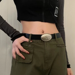 Close-up of vintage black leather belt with textured oval metal buckle on cargo pants