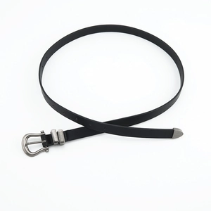 Detail of vintage silver metal buckle and tip on minimalist black leather belt