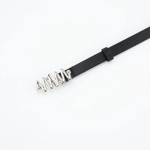 Detailed close-up of a slim black leather belt with silver wavy buckle and engraving