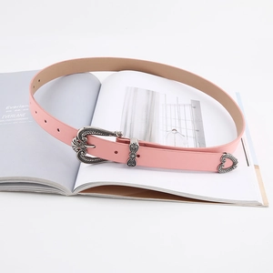 Detail of pink leather belt with vintage silver carved buckle and heart-shaped metal tip