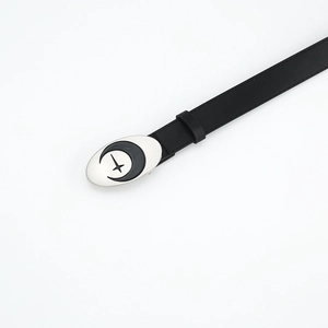 Detail showing a black slim leather belt with silver oval buckle and crescent moon motif