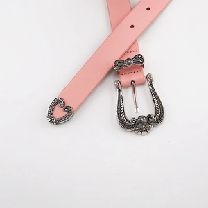 Detail of a pink vintage waist belt with silver engraved buckle and heart-shaped metal tip