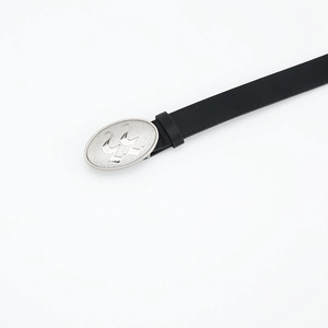 Detailed macro view of the oval matte silver buckle on a classic black leather belt