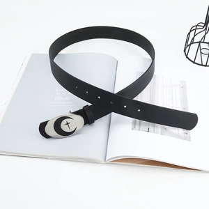 Detail of black leather belt with silver buckle featuring moon and star motif