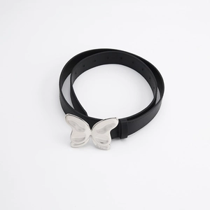 Détail d'une ceinture en cuir noir avec boucle en métal argenté en forme de papillon