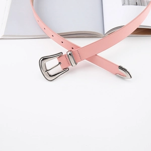Detail of light pink slim belt featuring vintage engraved silver buckle and metal tip