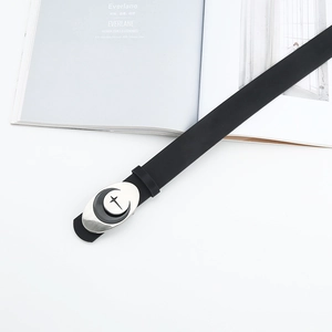 Detail of minimalist black leather belt with silver oval buckle and moon star engraving