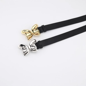 Détail de ceintures en cuir noir avec boucles papillon en métal doré et argenté