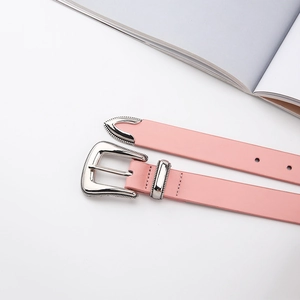 Detail of pink vintage western belt with silver carved buckle on minimalist background