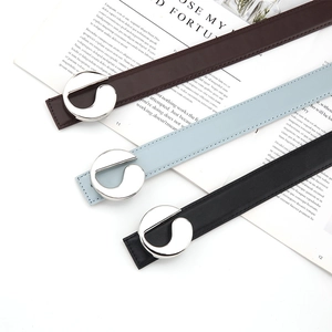 Detailed view of three women's leather belts with silver G-shaped buckles in various colors