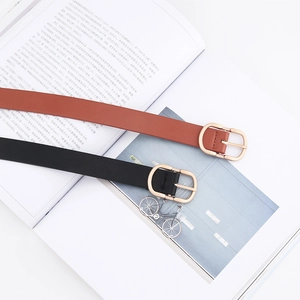 Detail view of thin black and brown leather belts with elegant golden D-shaped alloy buckles