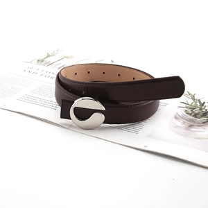 Minimalist dark brown leather belt with elegant silver metal ring buckle on magazine