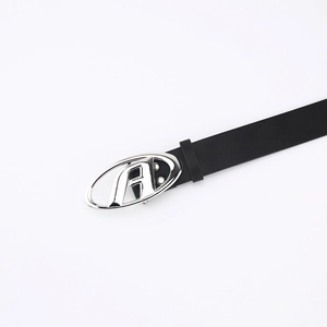 Detail of black leather belt featuring a silver oval buckle with hollow A-letter design