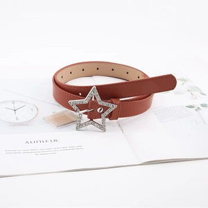 Detail of caramel leather belt featuring a sparkling rhinestone star shaped buckle