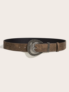 Close-up of vintage brown leather belt with embossed floral pattern and ornate silver buckle