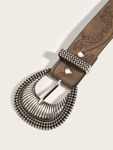 Detail shot of brown embossed leather belt with vintage floral patterns and silver buckle