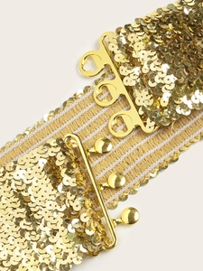 Détails des paillettes dorées en écailles de poisson sur une ceinture élastique large