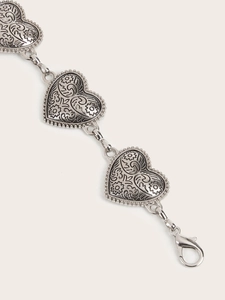 Close-up of vintage heart link chain with embossed floral patterns and lobster clasp