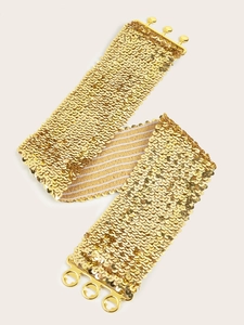Détail macro d'une large ceinture à paillettes dorées avec boucle métallique brillante