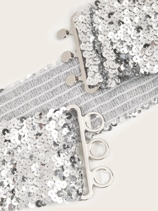 Détail macro de la ceinture élastique à paillettes argentées et fermoir à crochets
