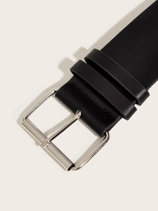 Close-up of black leather rivet belt featuring a silver rectangular buckle and dual loops