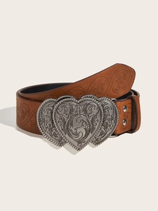 Détail d'une ceinture en cuir marron avec une grande boucle argentée en forme de cœur