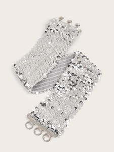 Détail de paillettes argentées sur une ceinture élastique avec boucle à crochet