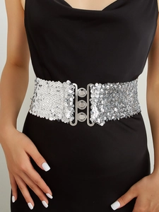 Gros plan d'une ceinture à paillettes argentées avec boucle à trois anneaux