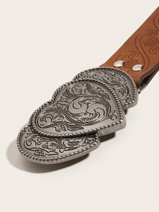 Gros plan d'une ceinture en cuir marron avec boucle en métal argenté à fleurs gravées