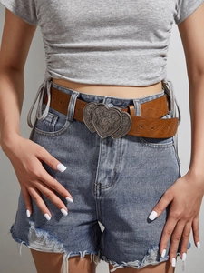 Détail d'une ceinture en cuir marron gaufré floral avec boucle à double cœur argent