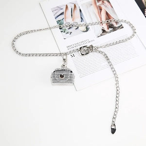 Close-up of silver metal waist chain with rhinestone mini bag charm and heart pendant